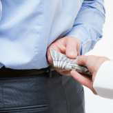 Female hand giving a bribe to businessman - closeup shot