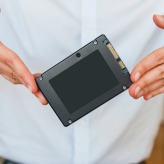 Hands holding fast flash SSD - solid state drive